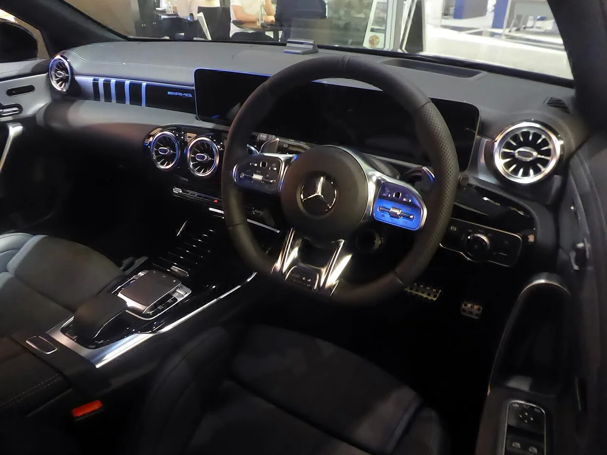 A 35 4MATIC 에디션 1의 우핸들 운전석 실내, AMG 스티어링과 디지털 계기판이 보인다