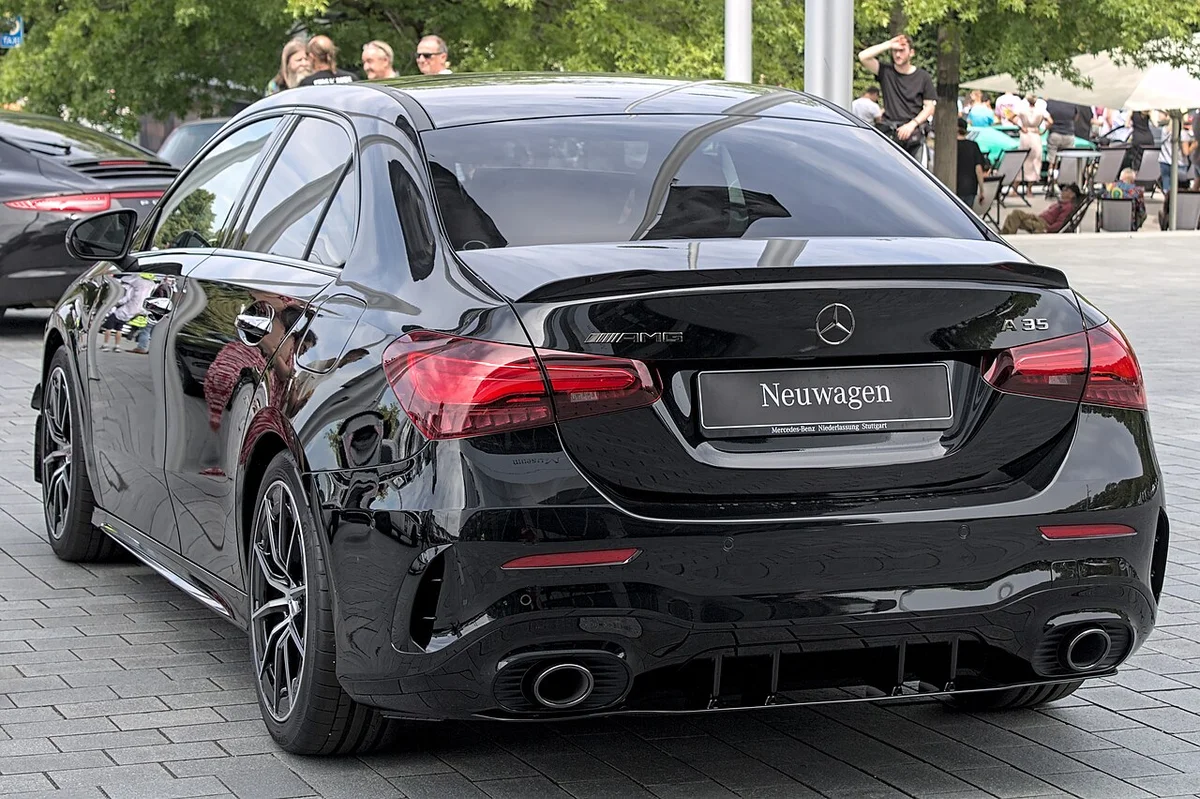 검은색 메르세데스-AMG A 35 4MATIC 세단의 후면, 트렁크 스포일러와 쿼드 머플러가 보인다