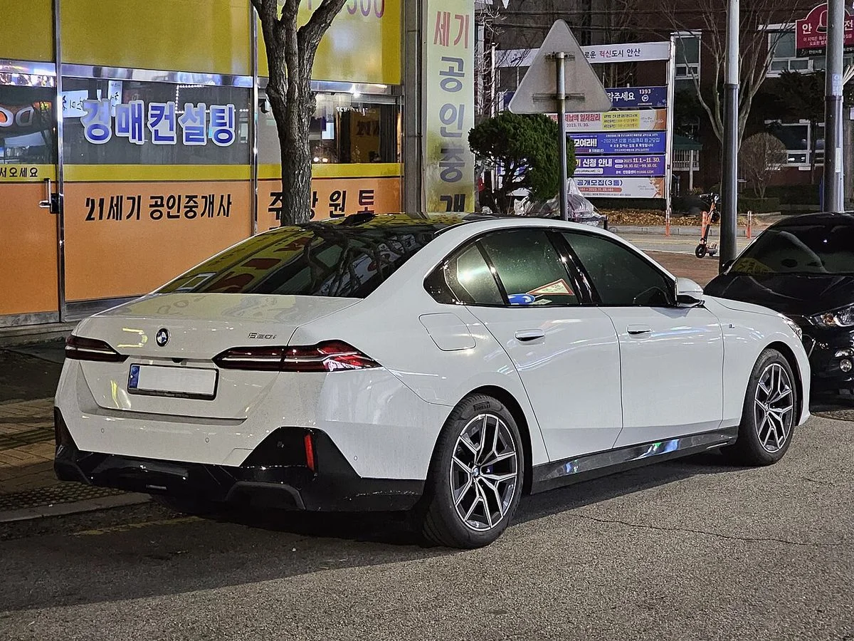 도로변에 세워 둔 흰색 BMW 5시리즈 G60의 후측면