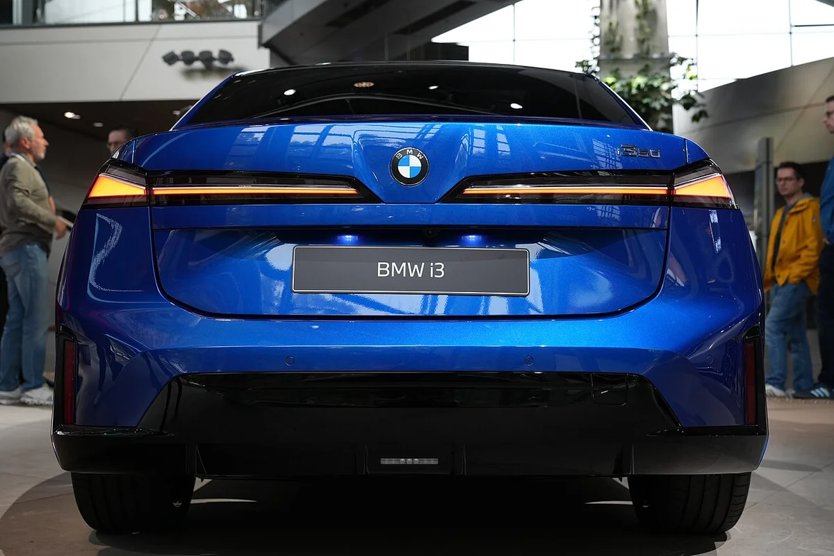 BMW 벨트에 전시된 파란색 BMW i3의 뒷모습, 가로로 이어진 리어램프가 보인다