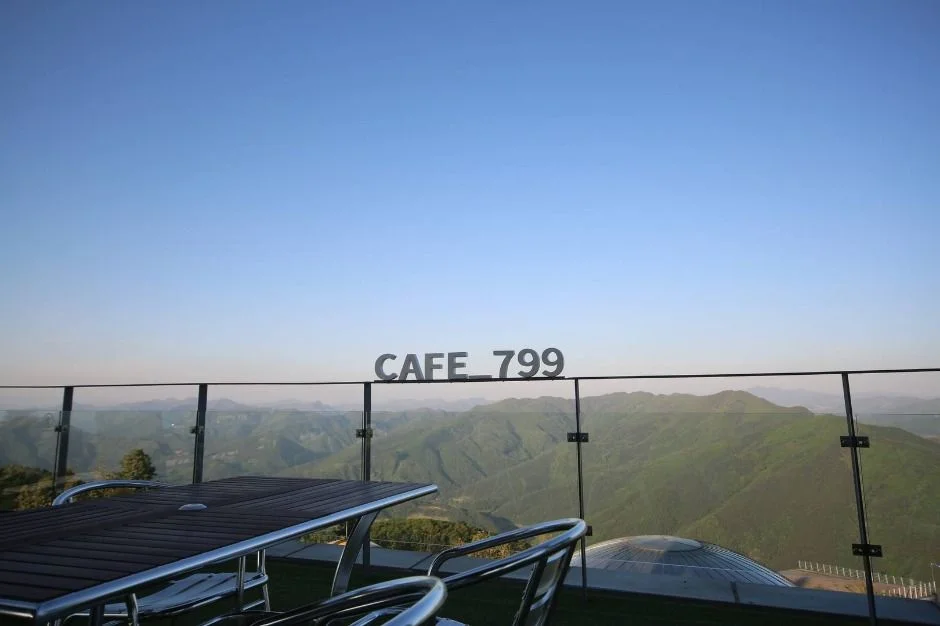 난간 너머로 산줄기가 보이는 CAFE_799 야외 테라스