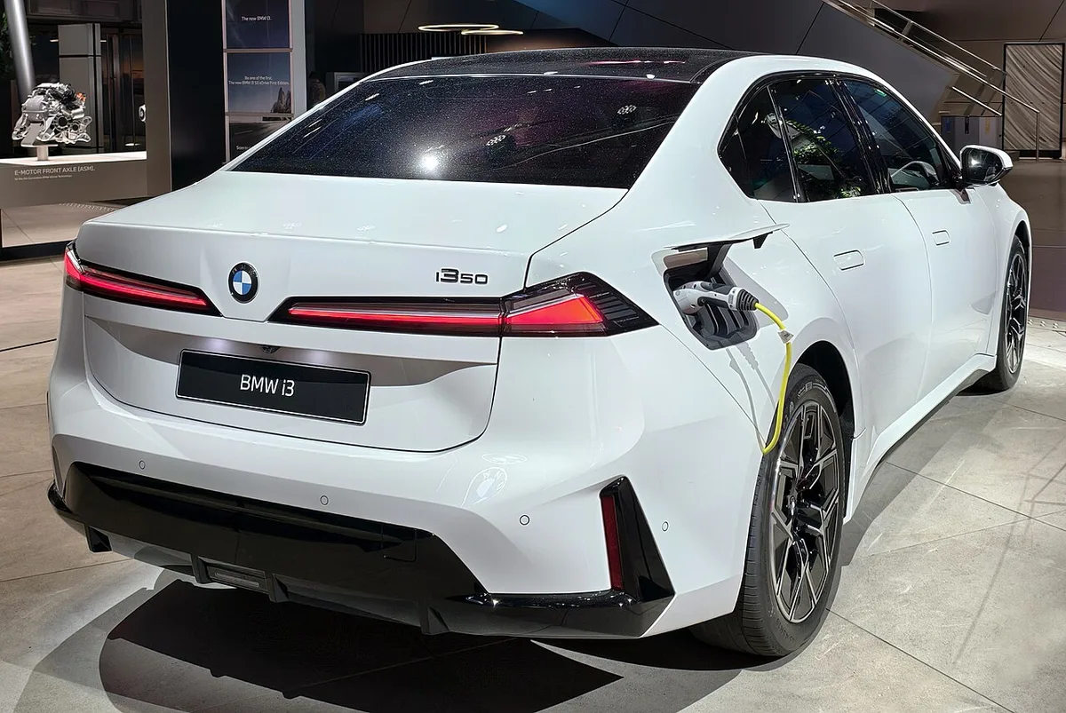 전시장의 흰색 BMW i3 50 후면, 충전 케이블이 꽂혀 있다