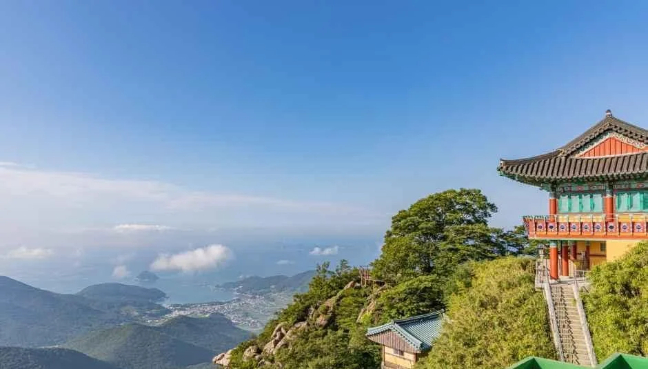 전각 지붕 너머로 바다와 해안 마을이 내려다보이는 조망
