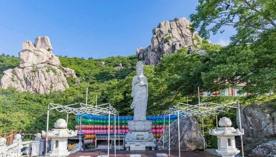 해수관음상과 연등 아래 기도 공간 뒤로 솟은 바위 봉우리