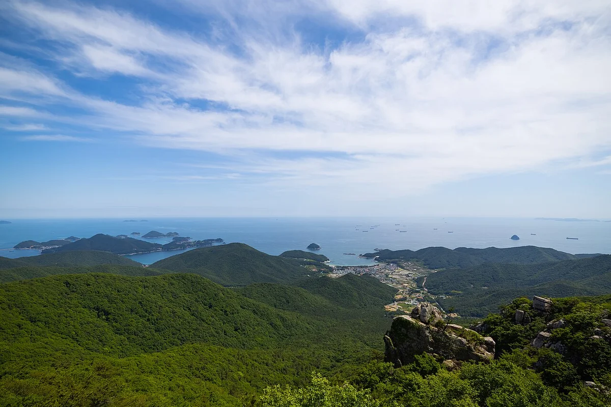 초록 산 너머로 섬이 점점이 보이는 남해 바다 조망