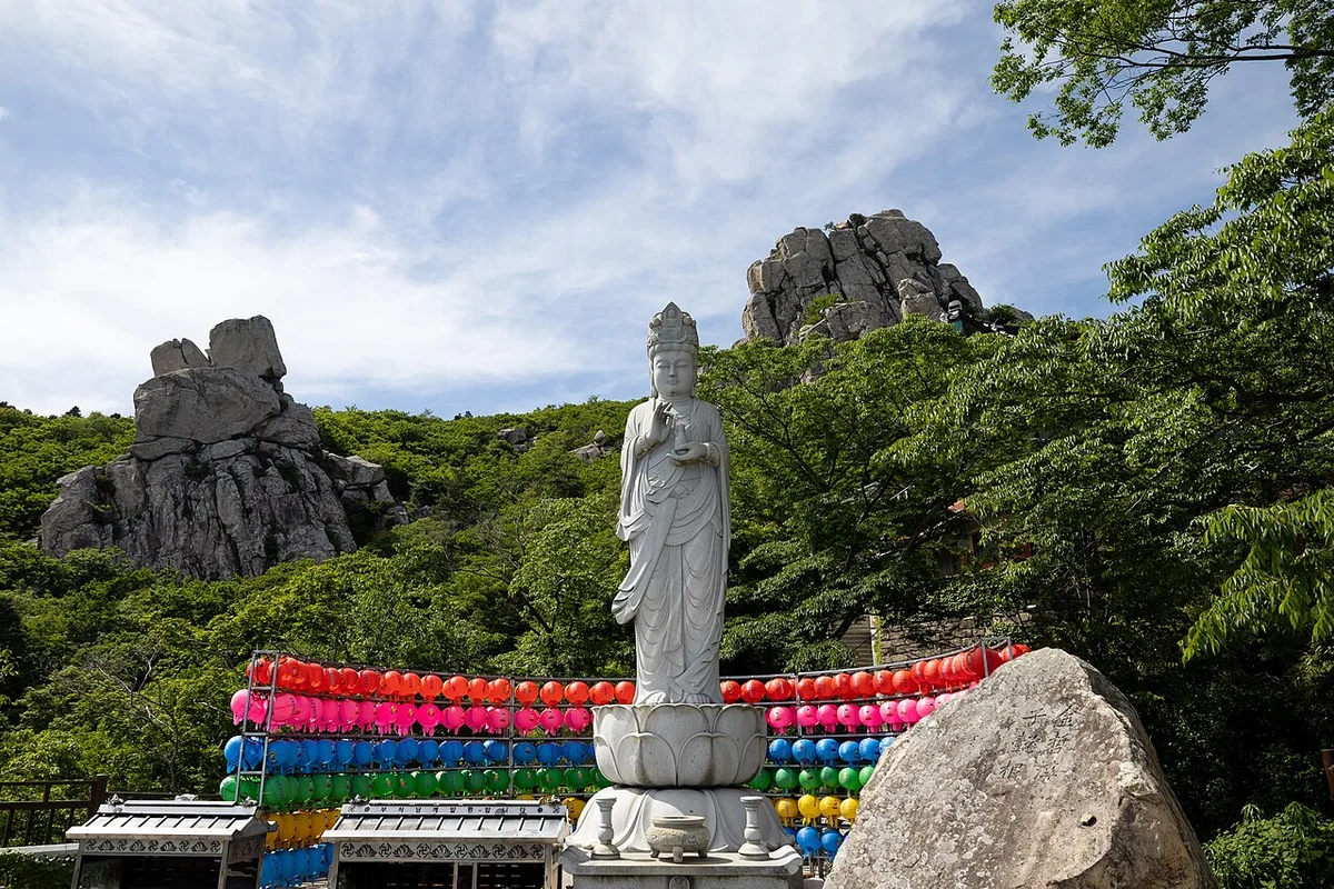 연등 위로 서 있는 해수관음상과 뒤편 기암