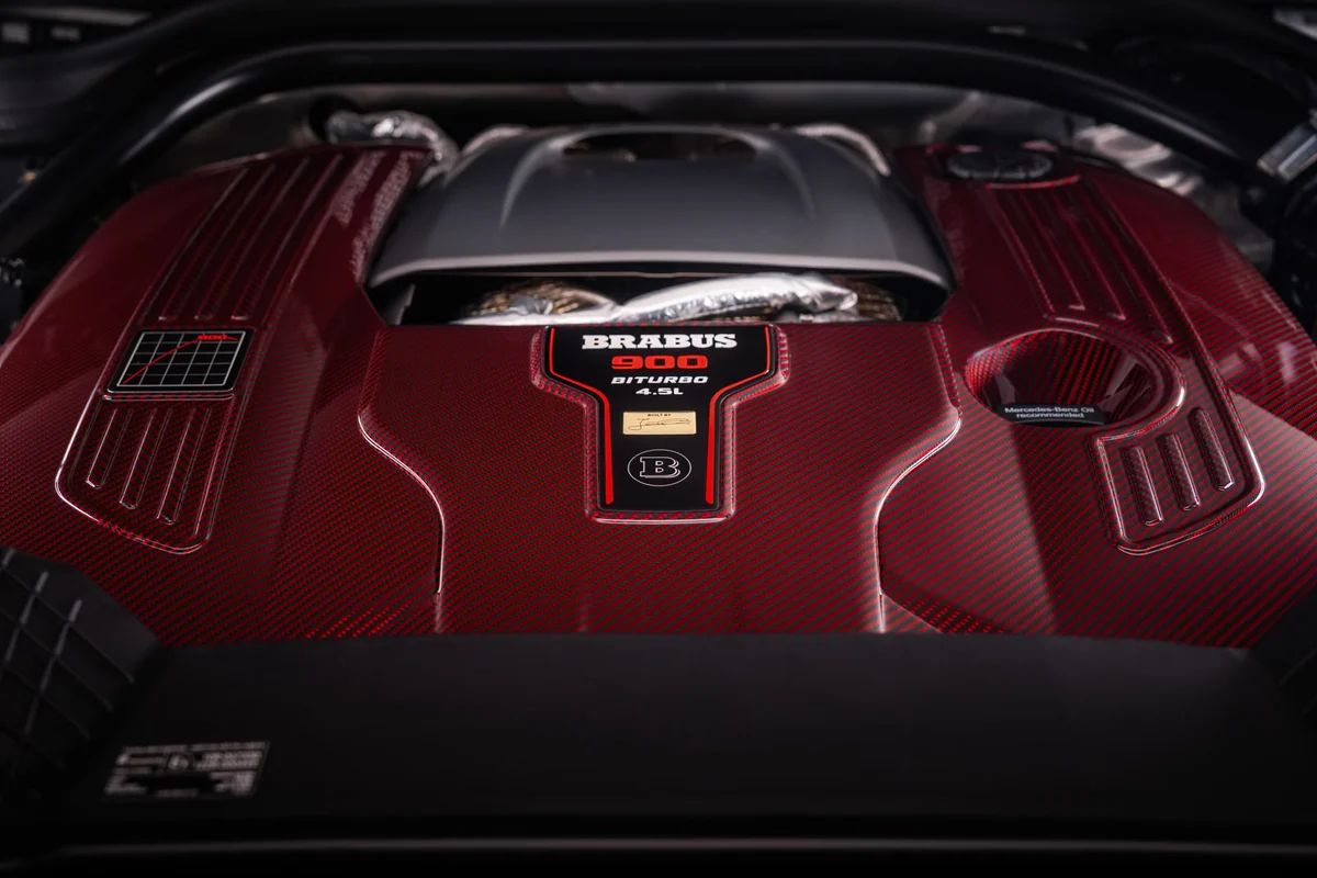 붉은 카본 엔진 커버에 BRABUS 900 BITURBO 4.5L 표기가 있는 V8 엔진룸