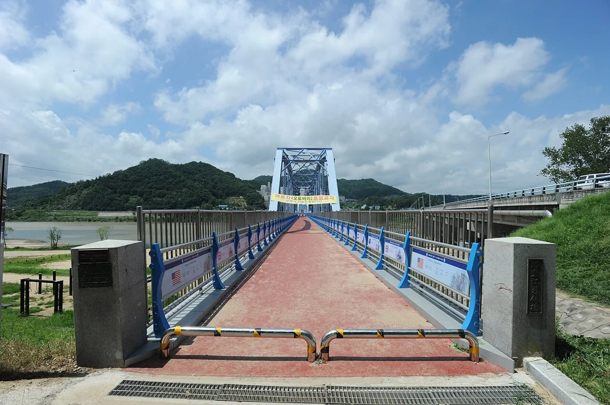 교각 위로 푸른 철제 난간과 붉은 보행로가 이어지는 낙동강 위 다리