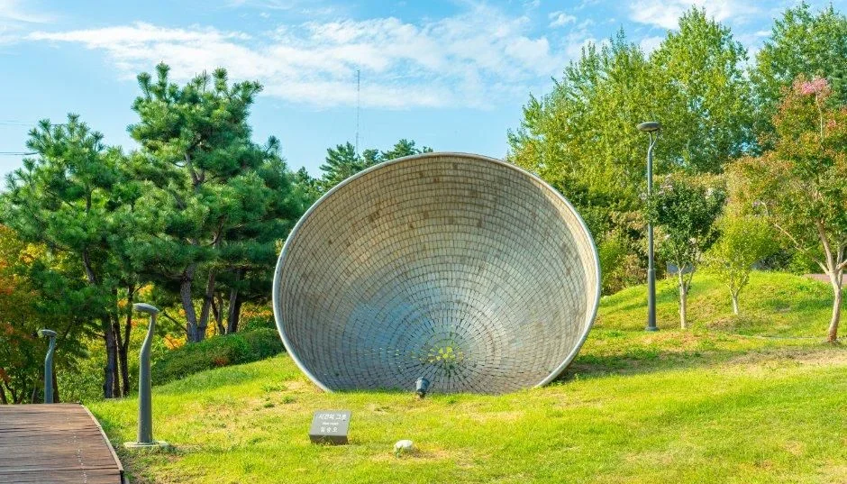 잔디밭에 놓인 거대한 조개 모양 은빛 조형물