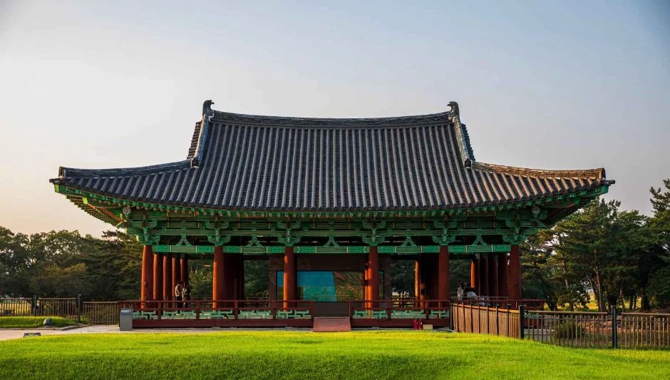 푸른 잔디 앞에 선 기와지붕의 월지 복원 전각