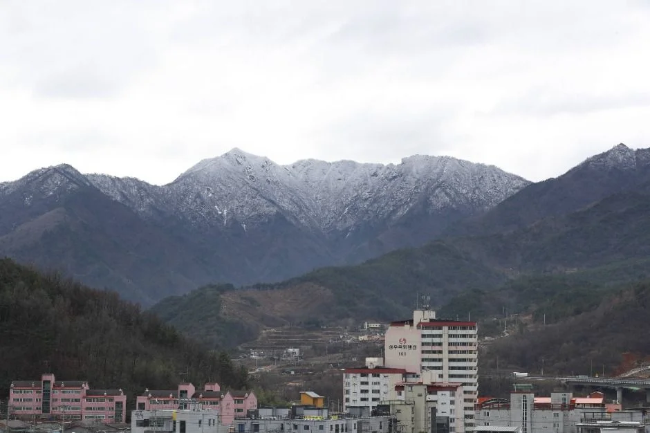 눈이 덮인 산줄기와 아래쪽 시가지