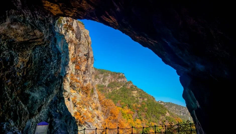 동굴 입구 너머로 단풍 든 산자락이 보이는 도선굴 안쪽