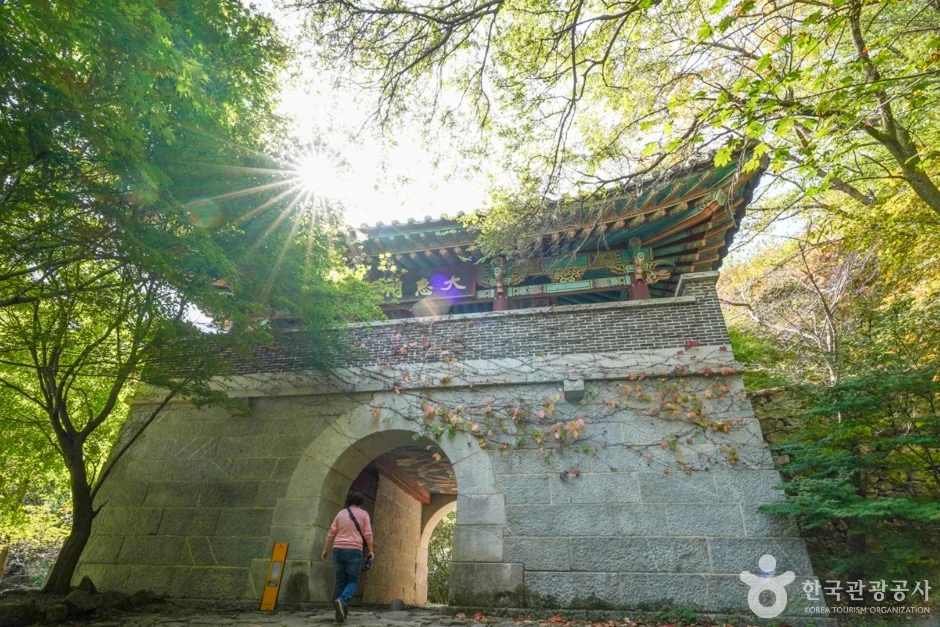 햇빛이 비치는 석축 성문과 문 아래를 지나는 사람