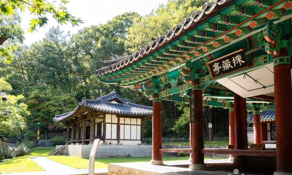현판이 걸린 채미정 정자와 뒤편 한옥 건물