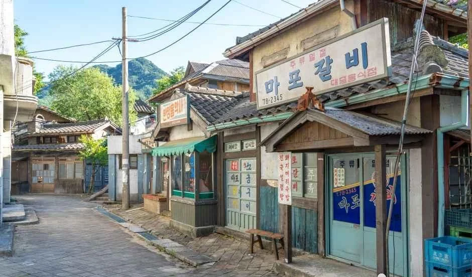 마포갈비 간판이 걸린 골목 세트와 뒤편 산