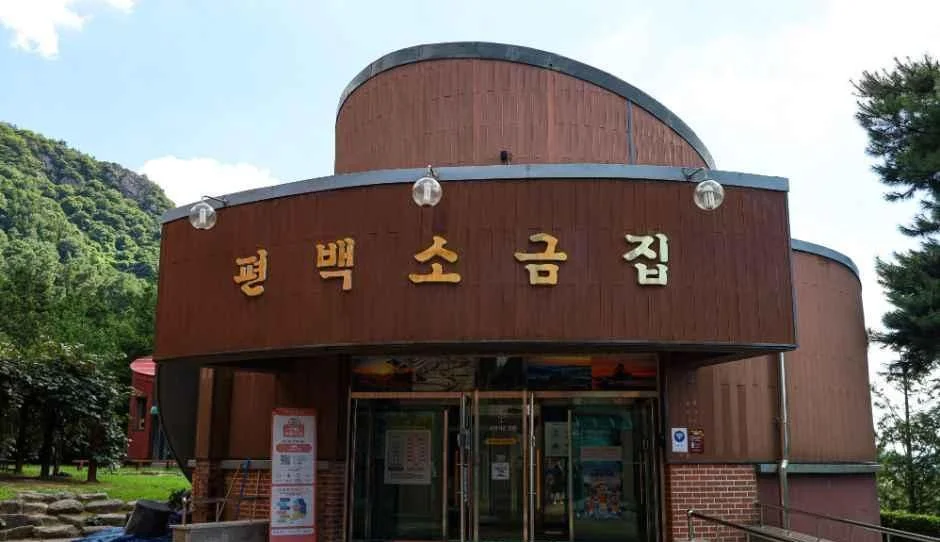편백소금집 간판이 걸린 갈색 원형 지붕 건물 정면