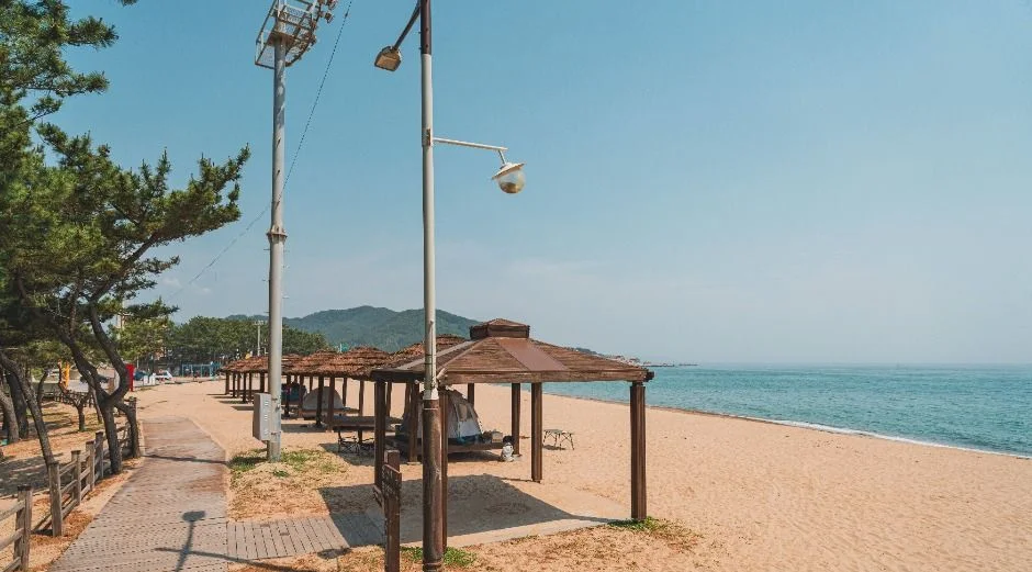 모래 해변 옆 산책로와 정자 한 곳