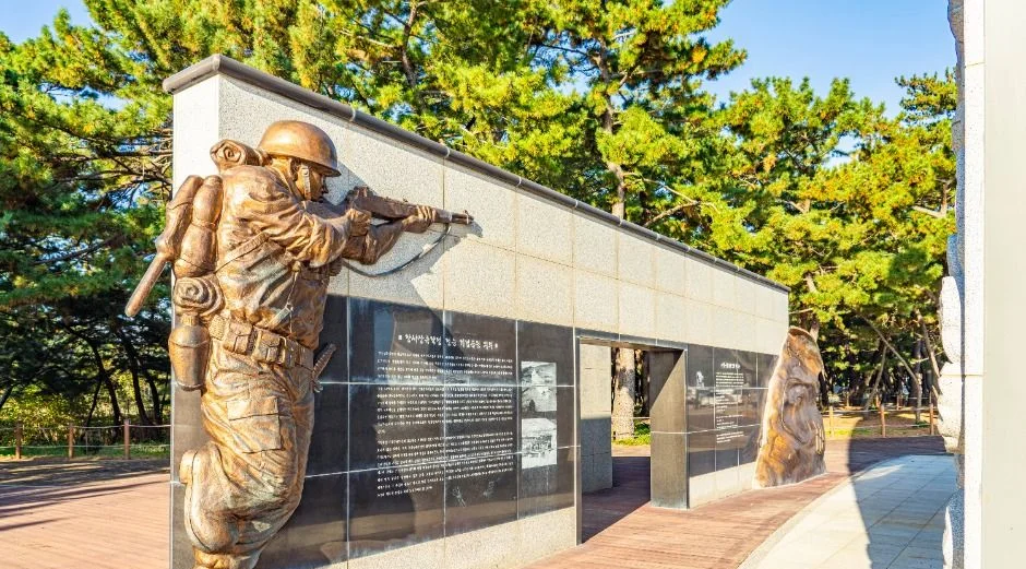 병사 부조가 새겨진 기념 벽과 붉은 보도