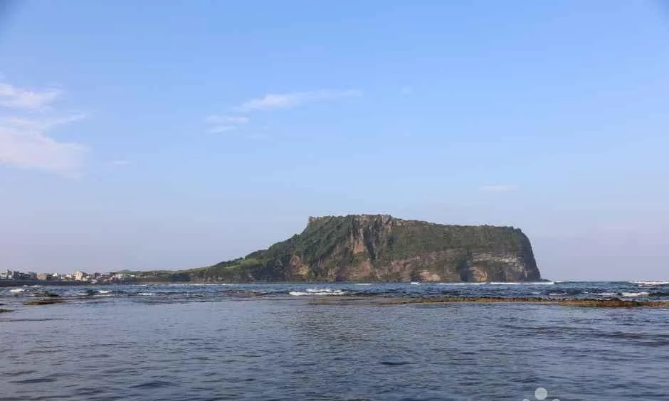 잔잔한 바다 건너 성산일출봉 능선이 보이는 풍경