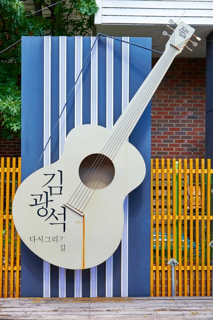 기타 모양 간판에 김광석 이름과 다시그리기길 글자가 적힌 표지