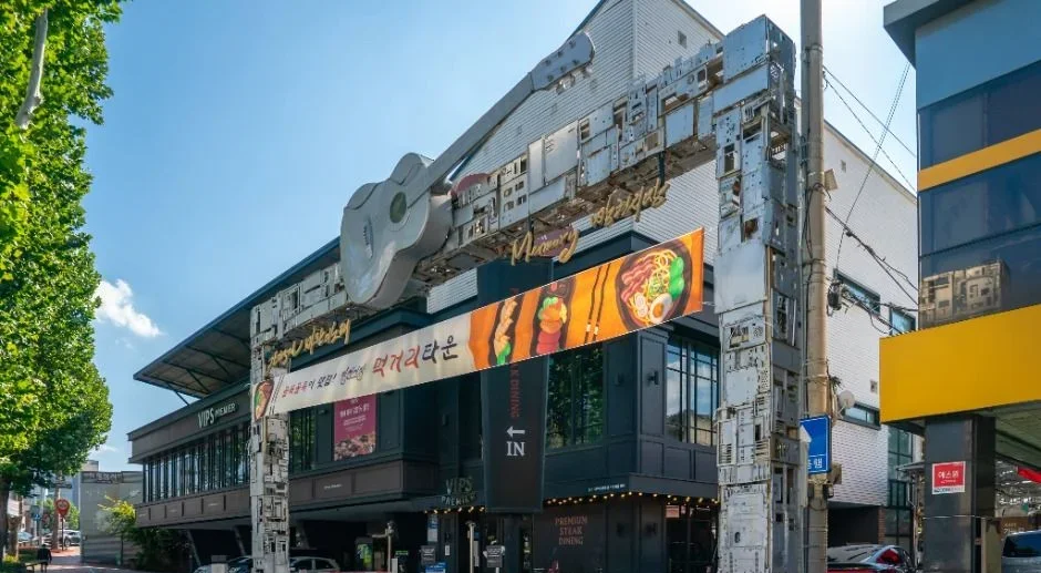 기타 모양 조형이 얹힌 건물과 도로