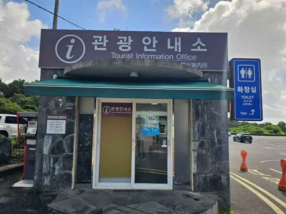 관광안내소 간판과 화장실 안내 표지가 있는 정방폭포 안내소 건물