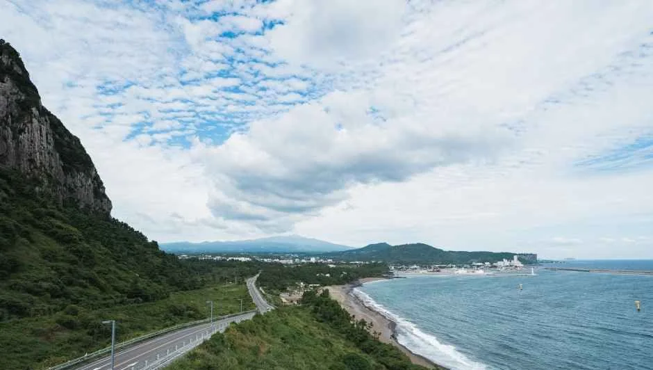 산자락 아래로 해안도로와 해변이 이어지는 풍경
